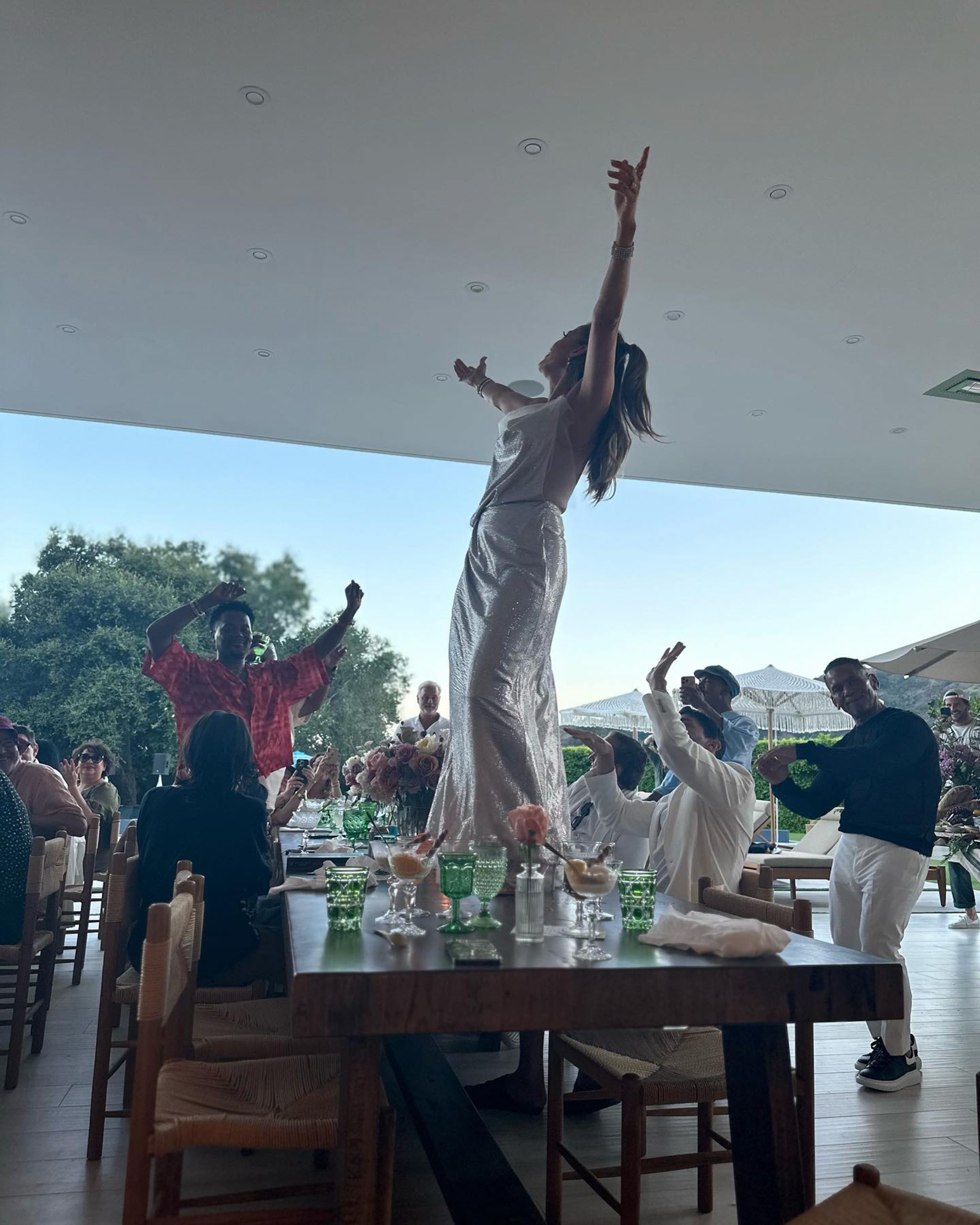 Jennifer Lopez, 54, wows in backless silver dress as she dances on table at birthday bash