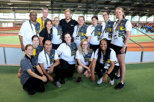 Prince Harry smiles with volunteers ahead of Invictus games in Germany without Meghan