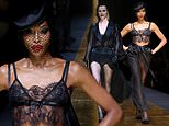 Naomi Campbell gives a glimpse at her midriff in see-through black lace top as she and Eva Herzigova walk in the Dolce & Gabbana show during Milan Fashion Week