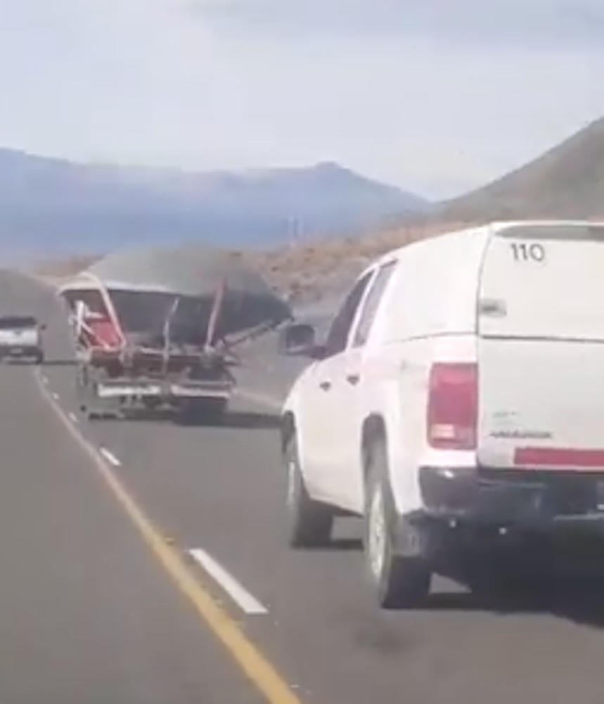 Bizarre photos show massive saucer-shaped ‘UFO’ being hauled down desert road by a tractor trailer baffling onlookers