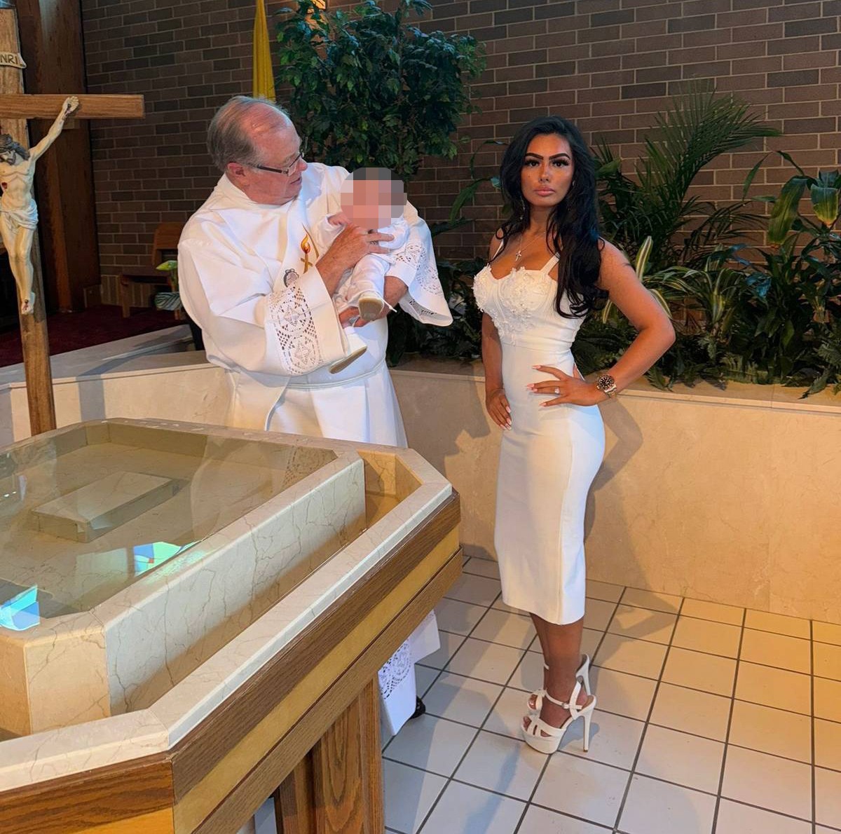 ‘So iconic’ people say as glam mum is posing at her baby’s christening – but some say they’re ‘praying’ for the tot